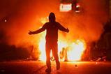 Fire burns near a demonstrator as riots continue in Ballymena, Northern Ireland