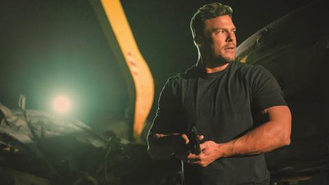 reacher-in-a-dark-shit-holding-a-pistol-at-the-ready-in-a-dark-salvage-yard-2
