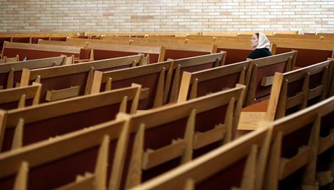 2020-12-28T153559Z_2017590297_MT1USATODAY15367760_RTRMADP_3_A-LONE-PARISHIONER-SITS-IN-THE-PEWS-DURING-GOOD-FRIDAY-MASS