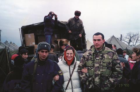 56.Armed escort protecting the team as they distribute food parcels at the tent refugee camp